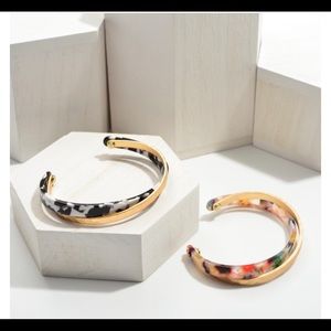 Resin cuff bracelet featuring hammered gold accents.